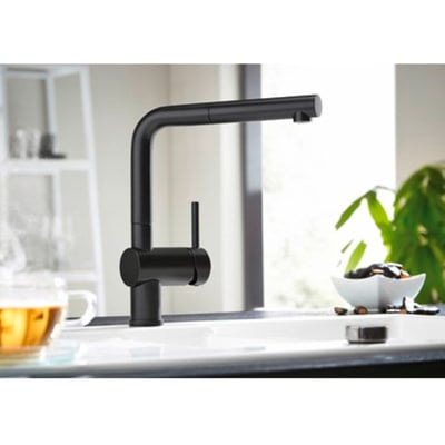 Blanco Linus-S køkkenarmatur i mat sort messing med L-tud og udtræksbruser, placeret ved en hvid vask.