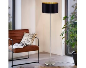 EGLO Maserlo gulvlampe i børstet stål med en cylindrisk sort skærm, der har en gylden inderside. Lampen står ved siden af en lænestol i et moderne rum.