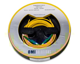 Launch Ring SingleMode 1000m med LC/UPC og SC/UPC stik, viklet i sort holder med OMI logo på hvid baggrund.