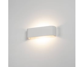 SLV MANA lampeskærm monteret på en hvid væg, der lyser opad og nedad med et blødt lys.