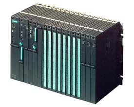 Siemens SIMATIC S7-400 PLC rack med flere moduler og etui, set fra siden med fokus på den sorte krop og grønne frontpaneler.