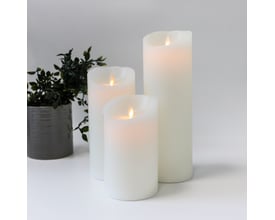 Sæt med tre hvide LED bloklys fra LEDlife med bevægelig flamme, arrangeret med en grå potteplante i baggrunden.
