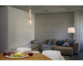 Ledvance LED kerte filamentpære med E27 sokkel i et moderne og hyggeligt rum med sofa og spisebord.