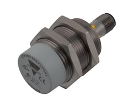 Carlo Gavazzi induktivaftaster M30 PNP NC med 15 mm rækkevidde, vist skråt med gevindhus og gule indikatorer.