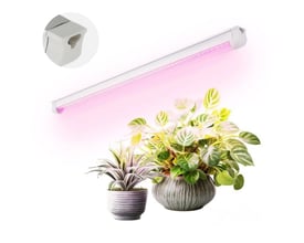 Hvidt Kobi GROWLY LED-vækstlysarmatur på 593 mm og 9 W lyser med pink skær over potteplanter.