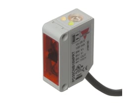 Carlo Gavazzi PD30CNG02NPR fotoaftaster med refleksion og 2 m rækkevidde, set skråt med gråt hus, rød front og kabel.