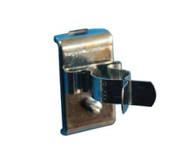 Fjederklemme med bagplade fra Maskinfabrikken Universal til Ø16mm rør, fremstillet i metal på hvid baggrund.