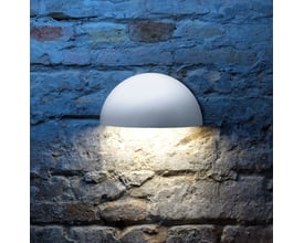 Lumenlight Bolero GII MIDI væglampe i hvid, monteret på en rustik murstensvæg med varmt lys nedad.