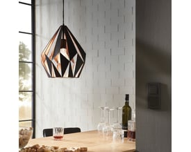 EGLO Carlton 1 pendel i sort og kobber med en diameter på 310 mm, monteret over et spisebord med vinflasker og vinglas.