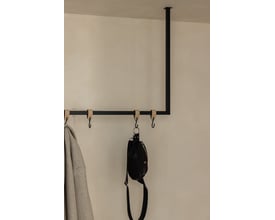 Metallbude Rubi tøjstativ i sort metal, lofthængt med 100 cm bredde og 60 cm højde, vist med en jakke og en taske.