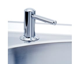 Sidevisning af Intra Juvel SD-Long sæbedispenser i krom, placeret på en poleret ståloverflade ved en vask.