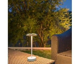 SLV VINOLINA ONE hvid akku bordlampe, lavet af aluminium, oplyser en terrasse om aftenen med varmt lys fra genopladeligt batteri.