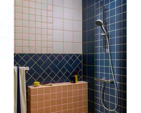Hansgrohe Activera Select S brusesæt i krom monteret på en væg med blå og lyserøde fliser.