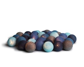 IrisLights lyskæde med tændte LED-lys i stofkugler i nuancer af blå og grå, der skaber en hyggelig stemning.