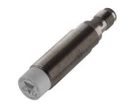 Carlo Gavazzi induktiv M18-aftaster med lang, forniklet metalcylinder, gevind og gråt sensorhoved, set skråt fra siden.