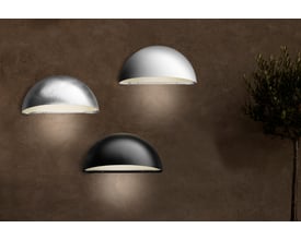 Lumenlight Bolero GII MIDI væglamper i galvaniseret, hvid og sort monteret på en rustik væg med oliventræ til højre.