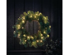 Veli Line grankrans Ø40 cm med 40 varm hvide LED-lys hænger på en mørk trædør, perfekt til juleudsmykning udendørs.