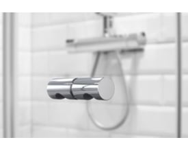 Vetro brusedørsgreb i krom med 5mm gevind, vist på en glasdør med brusearm i baggrunden.