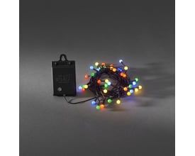 Nærbillede af en oprullet Konstsmide lyskæde med 40 farvede LED-lys og en sort batteriboks på grå baggrund.