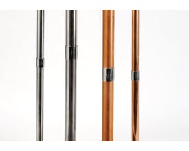 Forskellige rørtyper, herunder kobberrør og stålrør, med monterede Instalpress klemmeforbindere, vist på hvid baggrund.