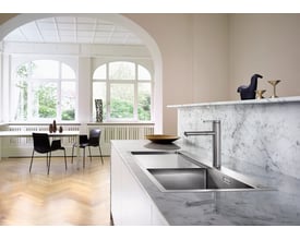 Blanco Claron 5S-IF MXI køkkenvask i rustfrit stål viser den integrerede afløbsbakke og en elegant vandhane i et moderne køkkenmiljø.