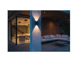 SLV MANA OUT udendørs væglampe monteret på en søjle med lysstråler op og ned, oplyser en terrasse med sofaer.