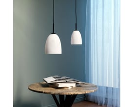 To Dyberg Larsen Jazz pendler D12, hvid opalglas med sort top, over et rundt bord med bog.
