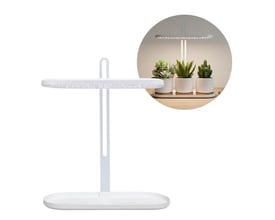Hvidt Kobi BLOOM grolys til krydderurter med LED-lysbjælke og justerbar stander; planter ses under lyset.
