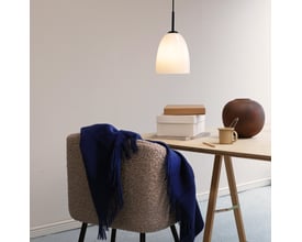 Dyberg Larsen Jazz pendel D18 i opalglas og sort metal, monteret over et arbejdsbord med en stol og dekorative genstande.