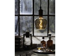 Brandy globe LED-pære med E27 fatning, 4W, 1800K, som hænger ned foran et vindue med flasker og et glas.