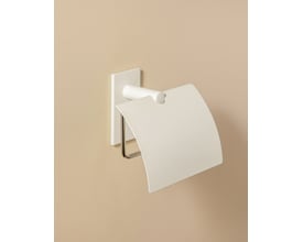 Cosmic toiletpapirholder med låg i mat hvid monteret på en lys beige væg, viser dens diskrete design og praktiske funktion.