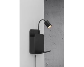 Nordlux Roomi væglampe i mat sort metal med bøjeligt lampehoved og opbevaringshylde, monteret på en lys væg.