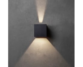 Sort Lumenlight Toscana udendørs væglampe med kantet form, monteret på grå væg og tændt med lys opad og nedad.