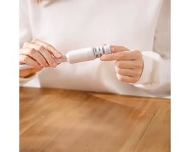 Philips filter til flaske, model AWP285/31, som en person monterer i et flaskehoved på et træbord.