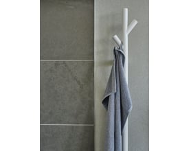 Smedbo dry håndklædetørrer i hvid mat med en gråmeleret håndklæde hængende på en af de tre arme, monteret på en betonlignende væg.