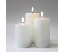 Tre hvide LED-bloklys med realistisk flammeeffekt, vist fra siden mod en hvid baggrund, alle lysene er tændte.