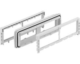 Spelsberg AK3 KFL sammenbygningsflange i lysegrå polystyrol (RAL 7035), vist i adskilte dele med tætningsring.