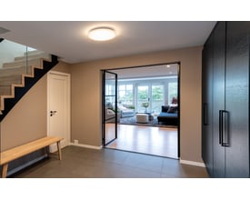 SG Armaturen Frosta 330, et rundt, hvidt væg-/loftarmatur med 3000K lys, monteret på et loft i en moderne entré.