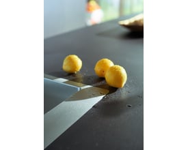 Hansgrohe S712-F660 vask i rustfrit stål med tre gule citroner og vanddråber på den mørke bordplade.