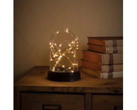 Nærbillede af Konstsmide glaskuppel med 30 amber LED-lys, der skaber en hyggelig stemning på en træoverflade.