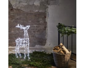 Star Trading Pegasus rensdyr med 120 LED lys er placeret udendørs på grangrene med en kurv med brænde i baggrunden.