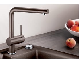 Blanco Linus køkkenarmatur i brun messing med 1-grebs betjening og svingbar L-tud, placeret ved en mørk bordplade og vask.