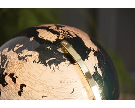 Nærbillede af den oplyste globus, der viser Europa og Asien med detaljerede landegrænser og bynavne.