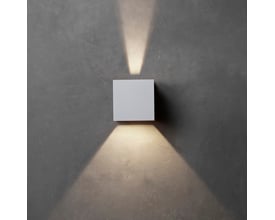 Hvid Lumenlight Toscana udendørs væglampe med up- og downlys monteret på en mørk væg.