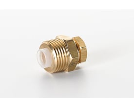 Nærbillede af EV Metalværk tankgennemføring med messingnippel og plastbøsning, viser gevind og tætningsdetaljer.