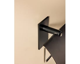 Cosmic toiletpapirholder med låg i mat sort, monteret på lys væg.