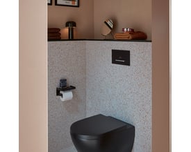 Villeroy & Boch ViConnect E300 betjeningsplade i mat sort med kromknap, monteret over et sort toilet.