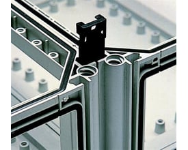 Close-up af Fibox MBFB sammenbygningskile, der forbinder hjørnerne af et Fibox SLN kabinet, med tydelige samlinger og gummipakninger.