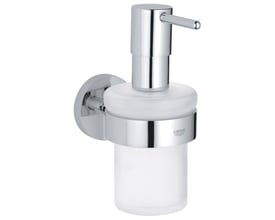 Grohe Essentials sæbedispenser i blank krom og frostet glas monteret på en væg med Grohe logo.