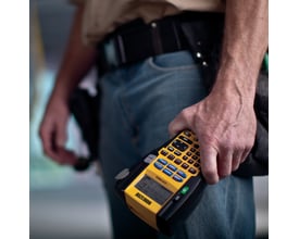 Mand holder DYMO® Rhino 5200 Pro labelprinteren i hånden, klar til industriel mærkning.